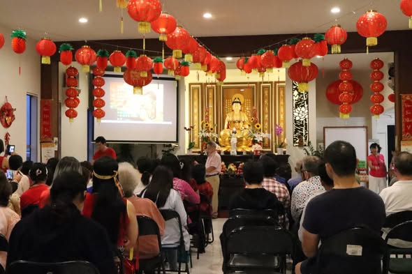 A community gathering in the main hall decorated with red lanterns